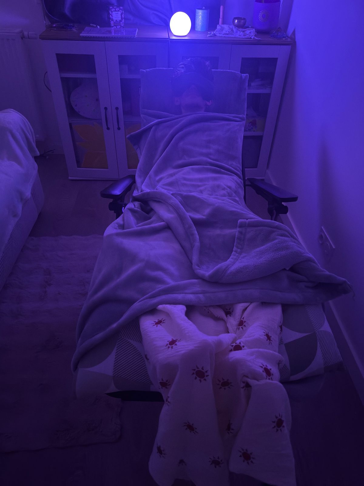 Séance de réflexologie sous plaid dans une ambiance tamisée et apaisante